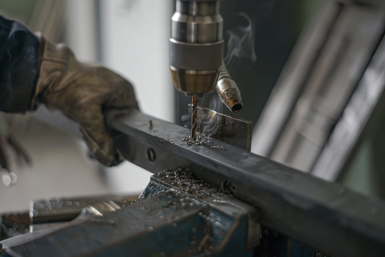 Focused view of a metal drilling process in an industrial workshop, highlighting precision machining.
